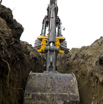 backhoe digging into soil